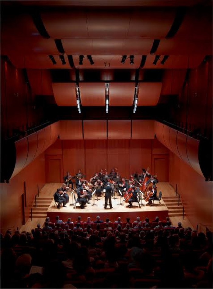 Orchestra performing on stage in a concert hall
